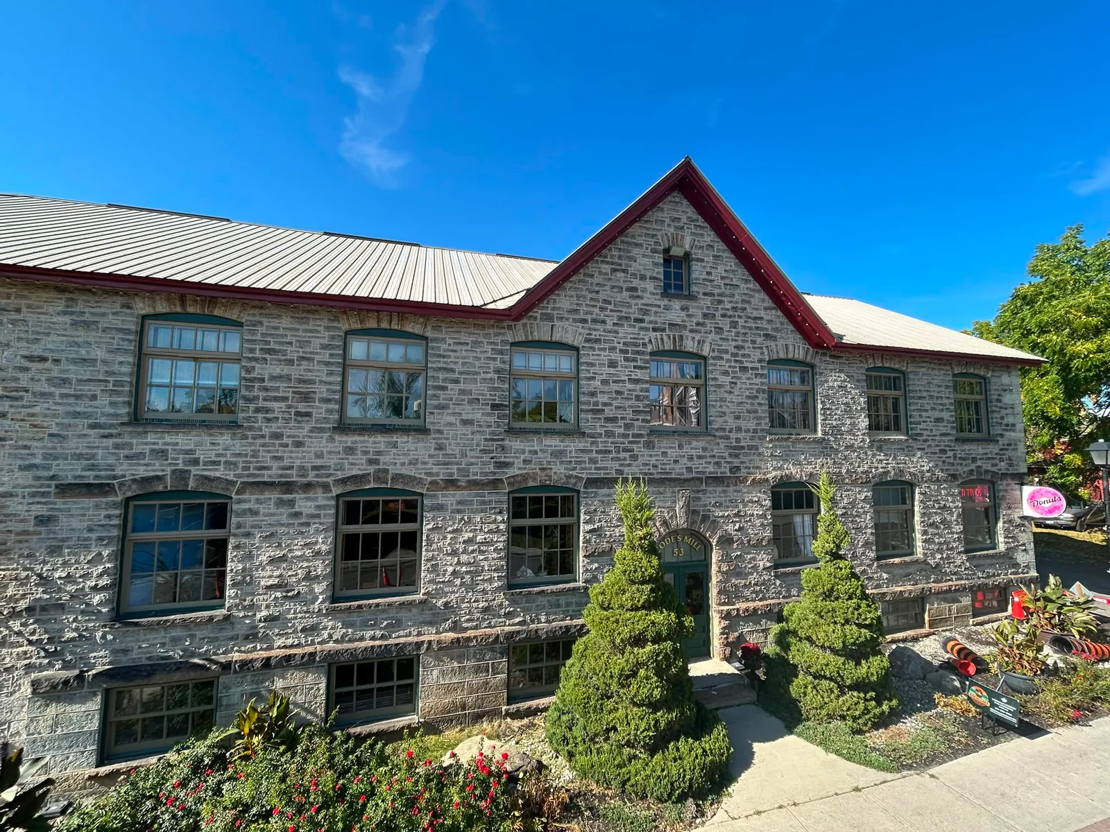 Freshly painted stone commercial building with metal roof in Perth, Ontario