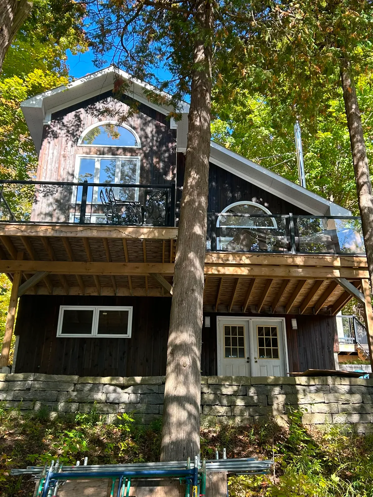Dark-stained lakeside cottage with a deck