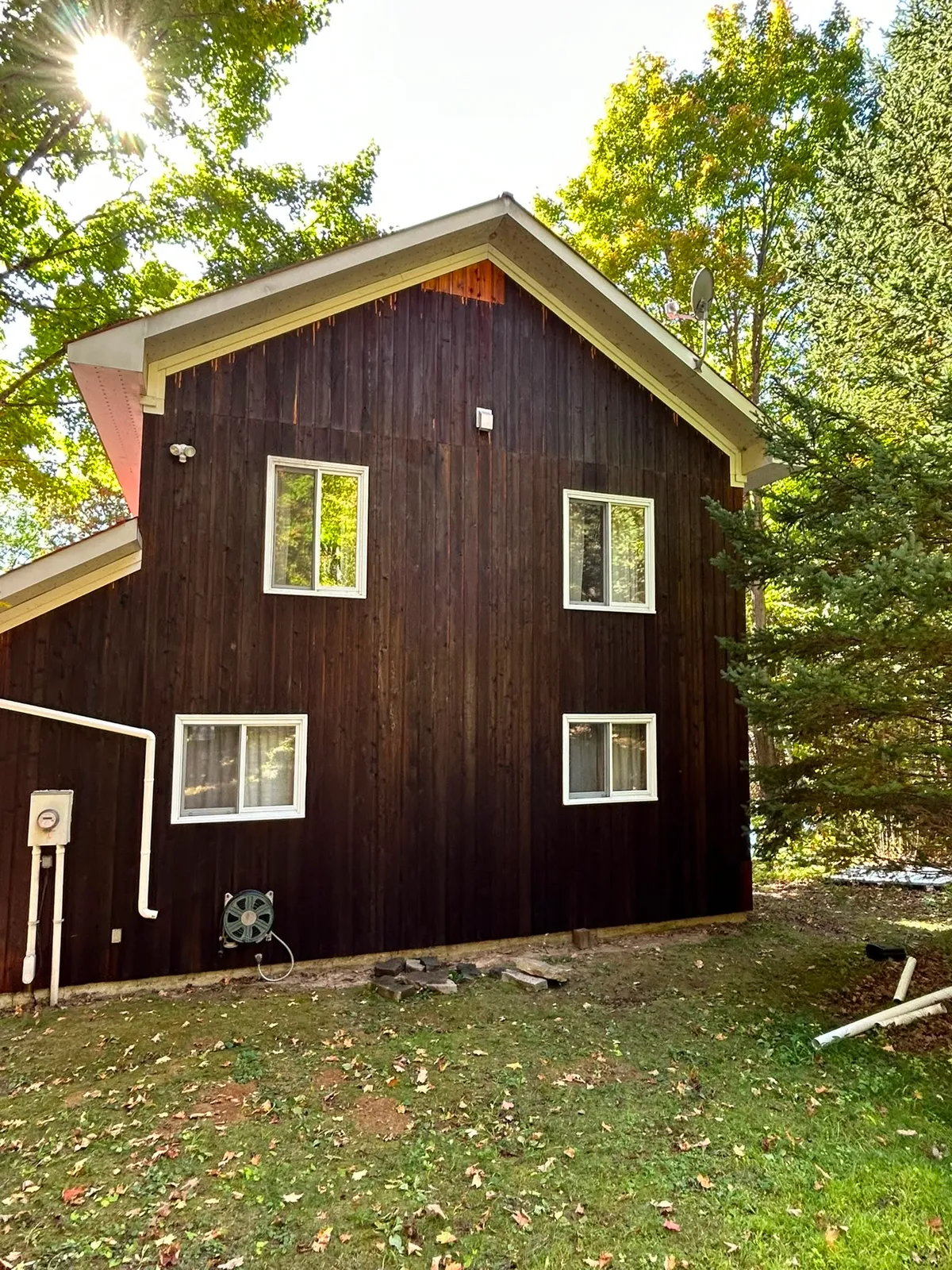 Dark-stained board-and-batten home exterior in the sun