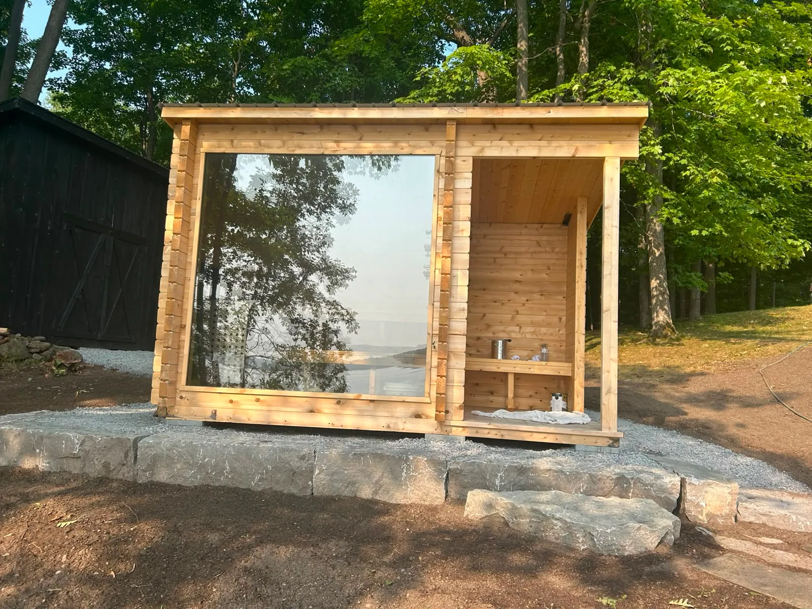 A cedar lakeside sauna cabin finished by McIntosh Painting & Maintenance in the Rideau Lakes