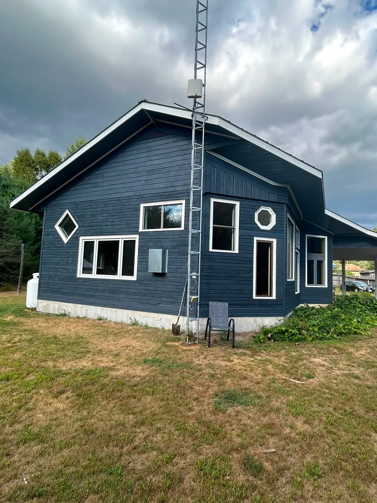 Navy-painted home with white trim and an octagon window